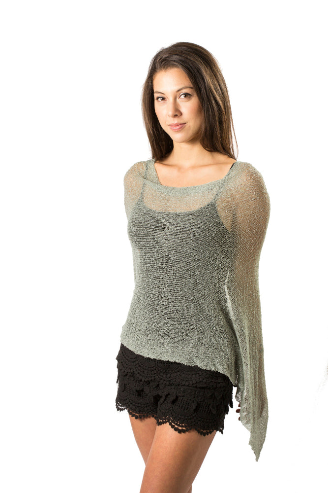 Woman wearing pale sage green sheer wrap over black outfit whtie background
