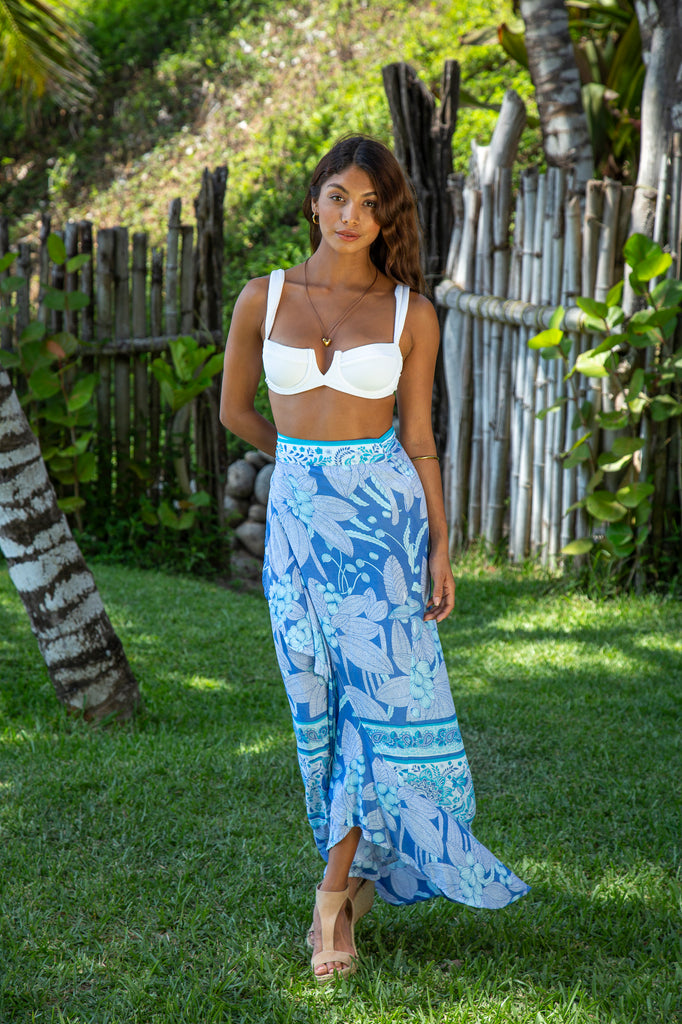 Woman standing wearing Brianna Convertible Wrap Skirt in Blue Hawaiian Print in a garden.