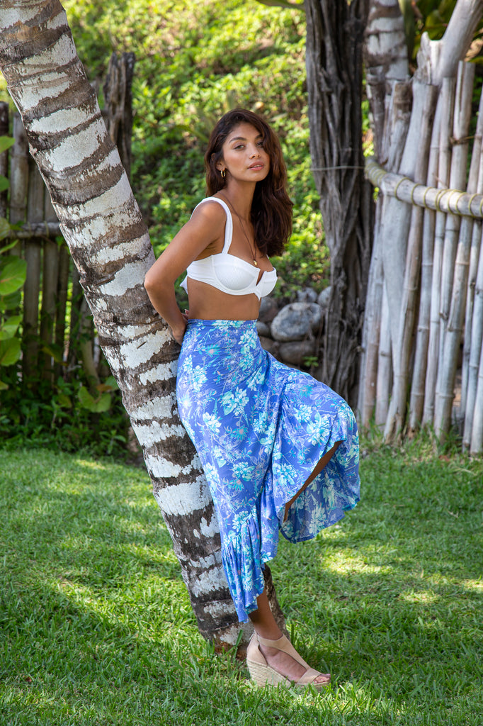 Woman standing wearing Brianna Convertible Wrap Skirt in Premium Laucala Blue in a garden.