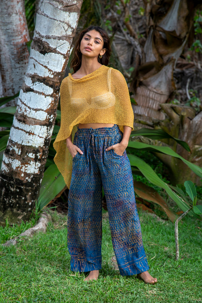 Woman wearing Gabrielle Wide Resort Pant in Denim Raindrop and versatile Gold Poncho (Sold separately).