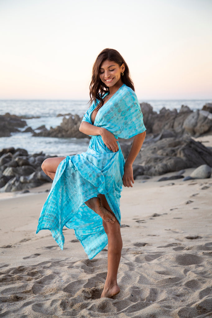 Side of a Woman wearing a Amy Kimono Dress in Premium Sophia Loren Turquoise Watercolor on a beach