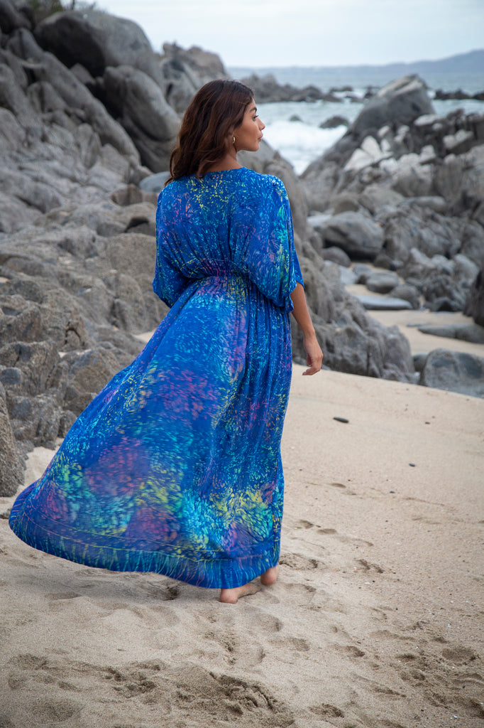 Back of a Woman wearing Amy Kimono Maxi Summer Dress - Bahamas Blue Rainbow Batik Sarong on a beach.