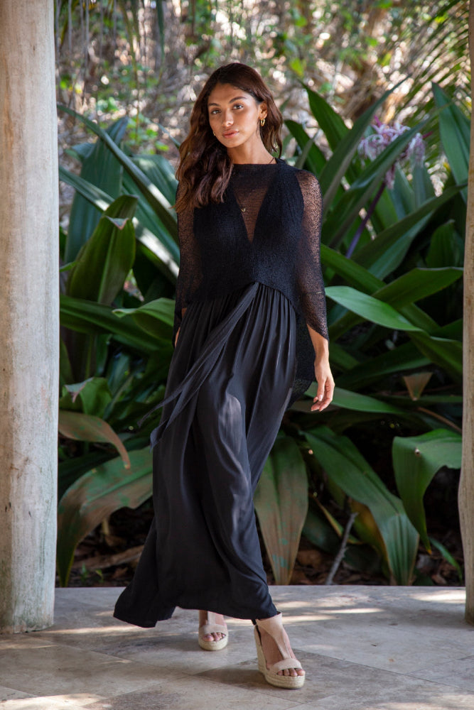 Woman standing upclose wearing Black #1 Knit Poncho Shawl over black dress in tropical setting