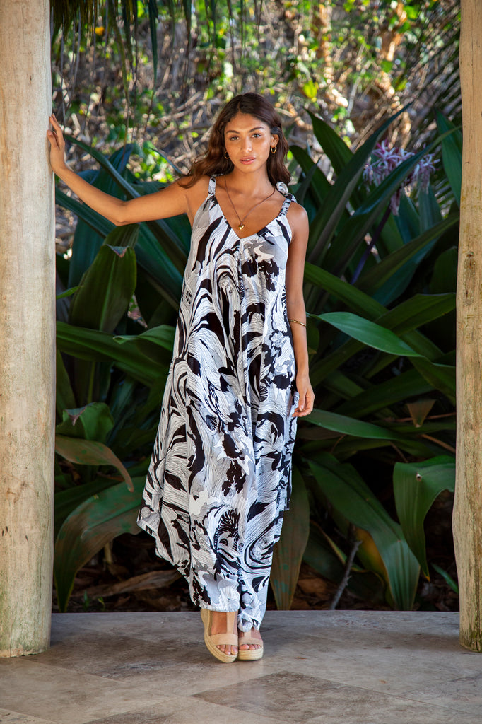 Front of a woman wearing Gypsy Jumpsuit Premium Antigua BW Abstract in front of a forest.