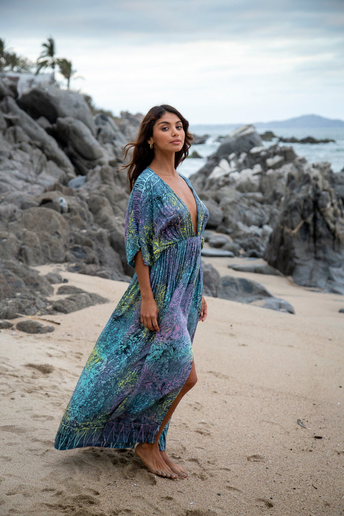 Side of a woman wearing Amy Kimono Maxi Summer Dress - Bahamas Grey Rainbow Batik Sarong on a beach.