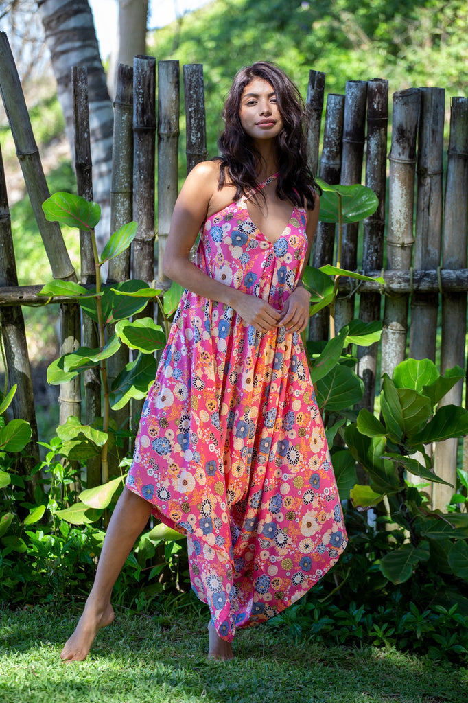 Front of a Woman standing wearing Gypsy Wide Leg Summer Jumpsuit - Okinawa Coral Pink with Pocket Option OS on a garden.