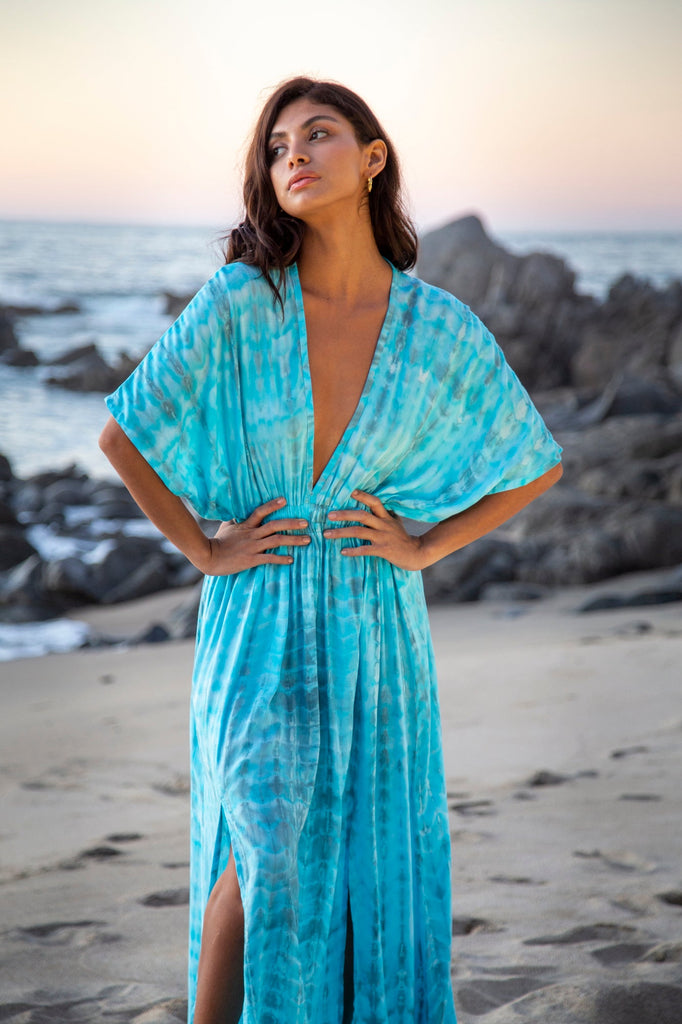 Woman wearing a Amy Kimono Dress in Premium Sophia Loren Turquoise Watercolor on a beach