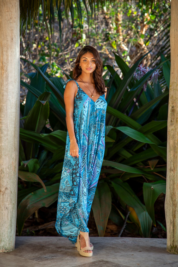 Front of a Woman wearing Wide Leg Jumpsuit Costa Rica Turquoise Leaf Batik in front of a forest.