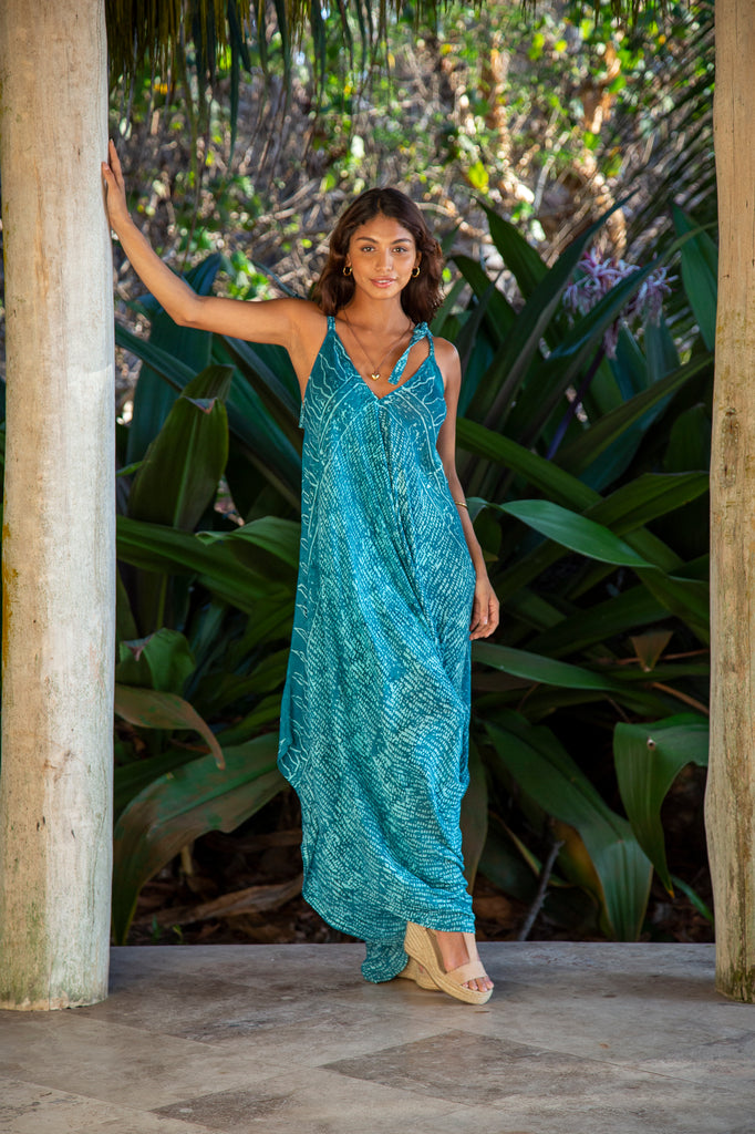 Front of a Woman wearing Wide Leg Jumpsuit Curacao Teal Code in front of a forest.