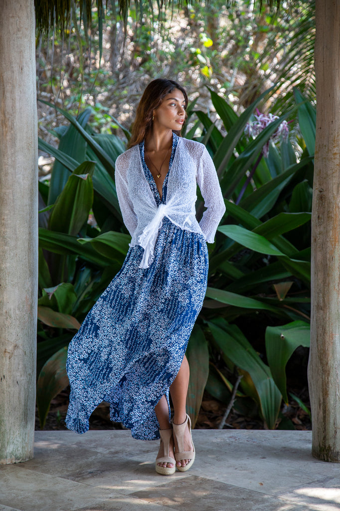 Front of a Woman standing wearing a Summer Knit Cardigan Bolero Shrug Cover in White in front of a forest.