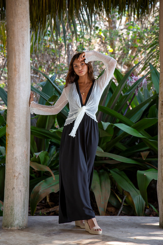 Front of a Woman standing wearing a Summer Knit Cardigan Bolero Shrug Cover in Off-White in front of a forest.