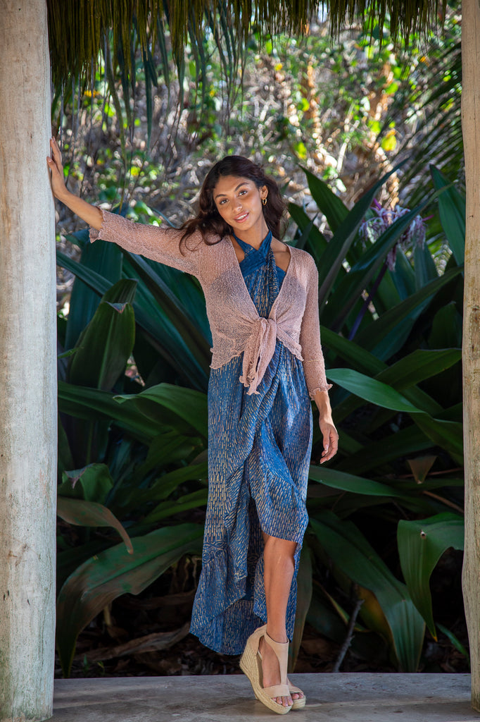 Front of a Woman standing wearing a Summer Knit Cardigan Bolero Shrug Cover in Champagne Beige in front of a forest.