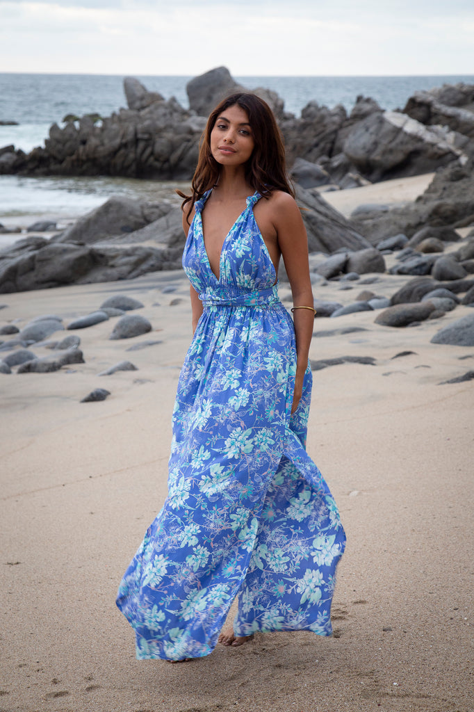 Front of a woman wearing Laucala Blue Floral Tammy Infinity Dress OS on a beach.