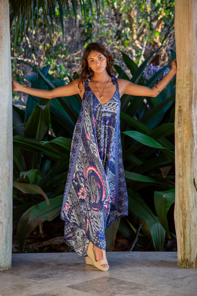 Front of Woman in Gypsy Wide Leg Jumpsuit in Turks and Caicos Dark Peri Pink Leaf Batik in front of a forest.