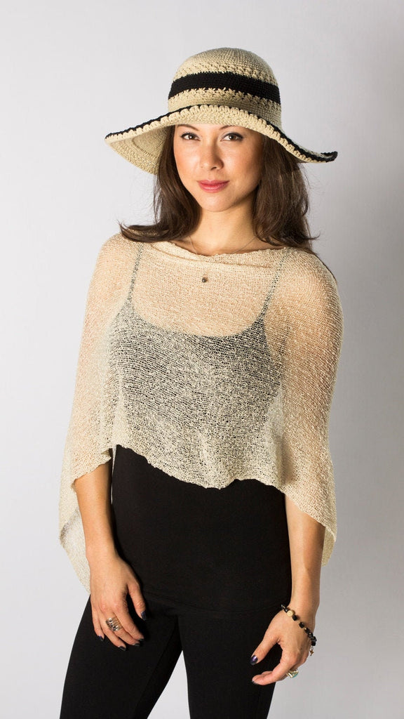 Woman standing upclose wearing Antique Cream Sheer Travel or Wedding Knit Poncho Shawl with hat and black outfit
