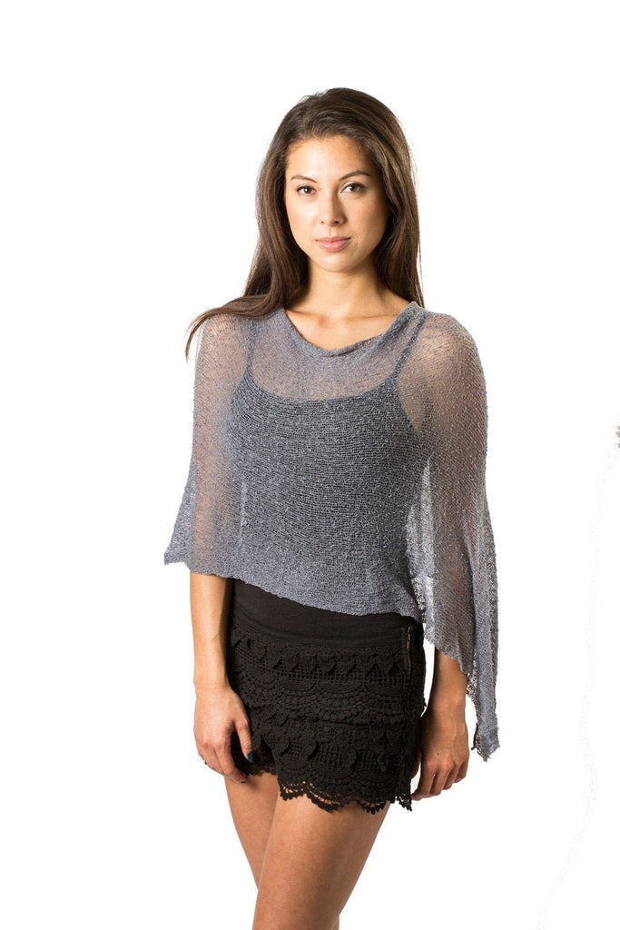 Woman wearing blue grey sheer knit lightweight poncho shawl wrap for resort, wedding, beach, nursing, travel, events, over black outfit and white background 