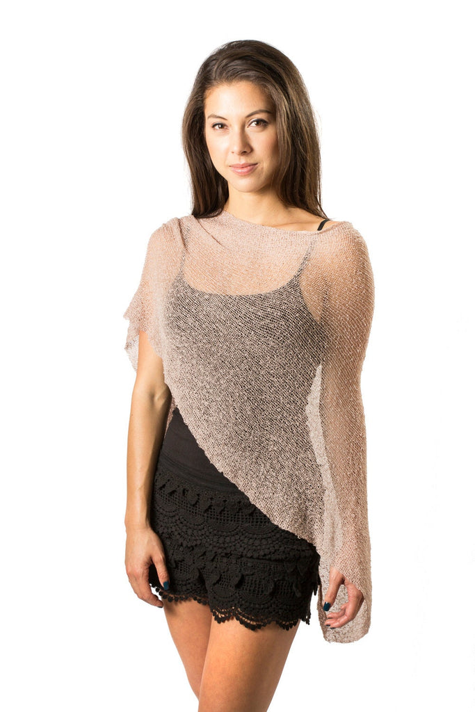 Woman standing upclose wearing Nude sheer Knit Poncho Shawl over black shorts white background