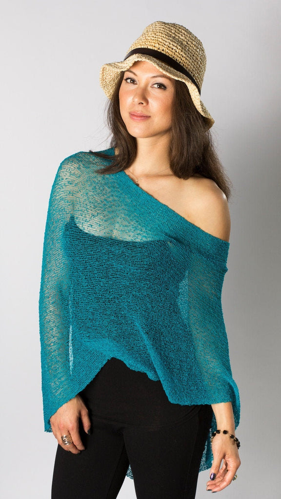 Woman wearing Teal Turquoise sheer knit lightweight poncho shawl wrap for resort, wedding, beach, nursing, travel, events, over black outfit and white background