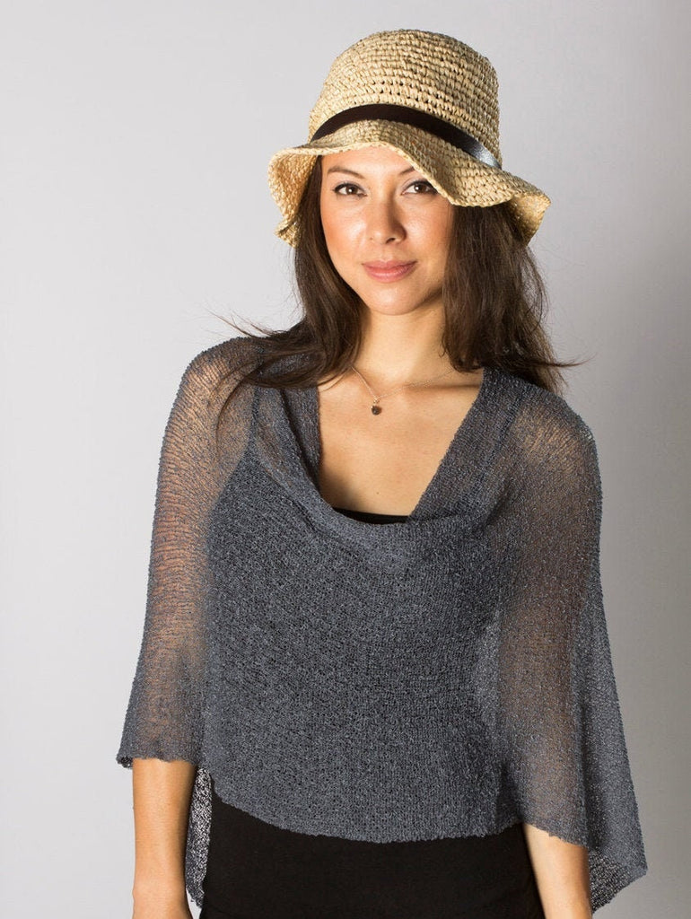 Woman wearing sheer grey knit lightweight poncho shawl wrap for resort, wedding, beach, nursing, travel, events, over black outfit and white background
