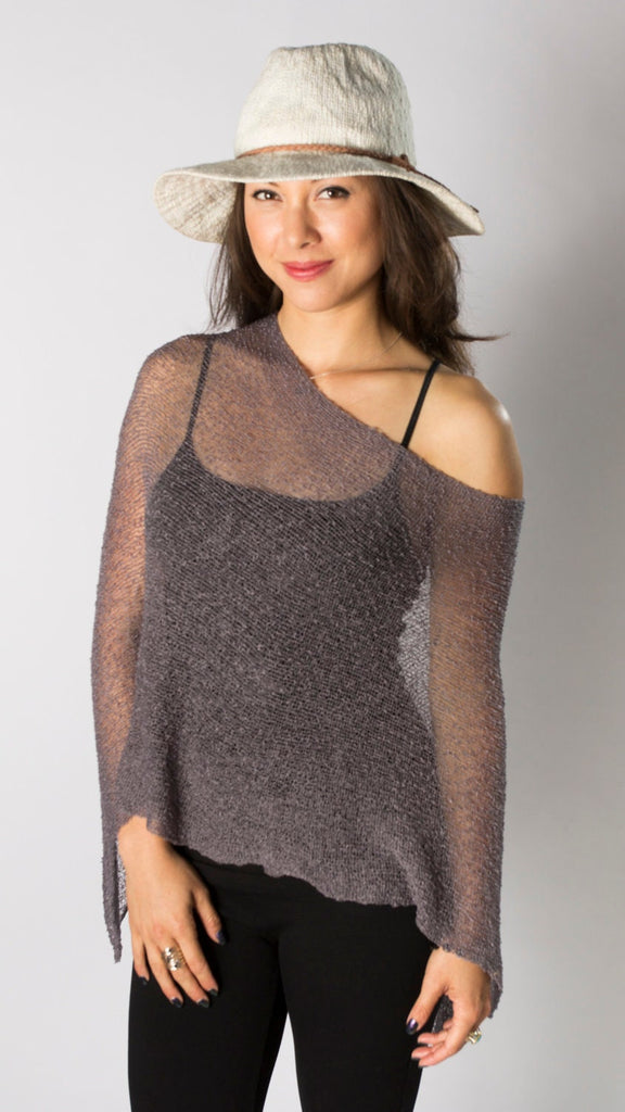 Woman wearing purple gray sheer knit lightweight poncho shawl wrap for resort, wedding, beach, nursing, travel, events, over black outfit and white background